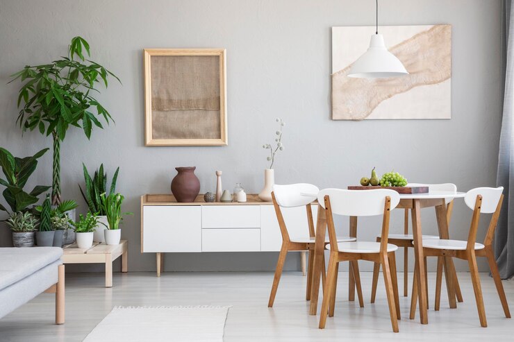 Foto echte foto van lichte eetkamer interieur met houten tafel en vier stoelen posters met stoffen verse planten geplaatst op houten platform en kast met decor