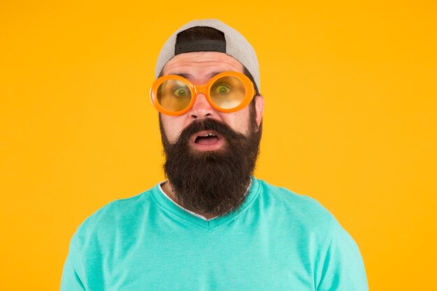 Echte verrassing freaky man met baard en snor man in grappige bril op gele achtergrond heb gewoon plezier feestaccessoire verraste man draag een bril in hipster stijl mannelijke zomerfeestmode