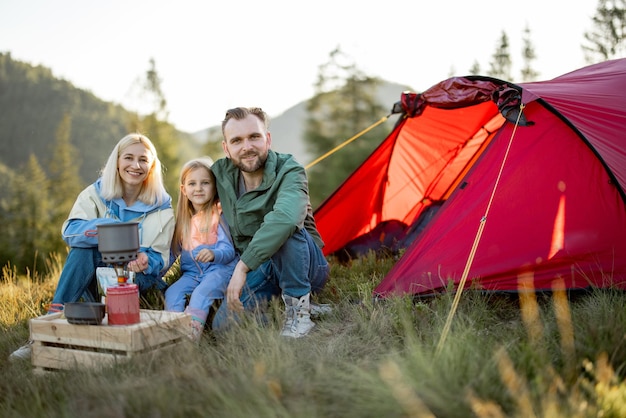 Echtpaar met meisje gaat picknicken op camping in de bergen