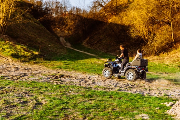 Foto echtpaar rijdt graag op een quad op bosheuvels