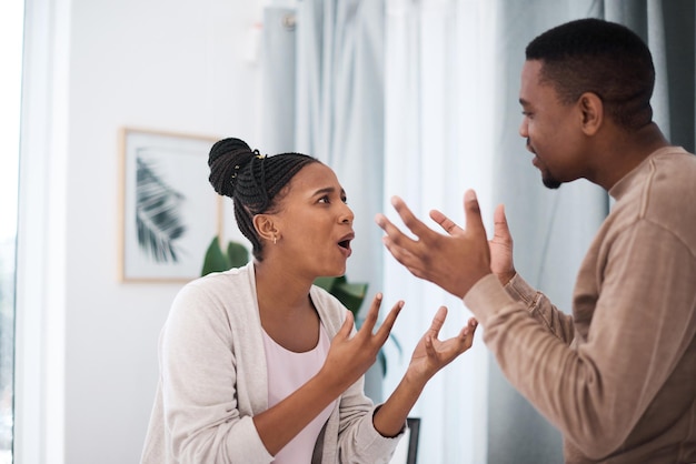 Foto echtscheiding, boos of zwart koppel maakt ruzie over geldlening, hypotheekschuld of financiële problemen thuis in nigeria woedecommunicatie en gestresste zwarte vrouw die tegen een gefrustreerde afrikaanse partner schreeuwt