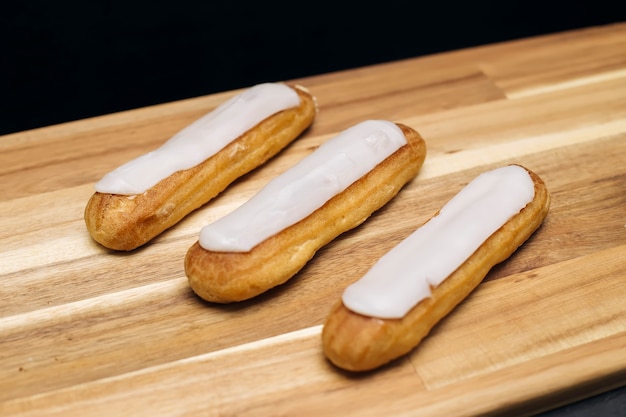 Eclair knapperige romige cake met witte chocolade geïsoleerd op houten oppervlak