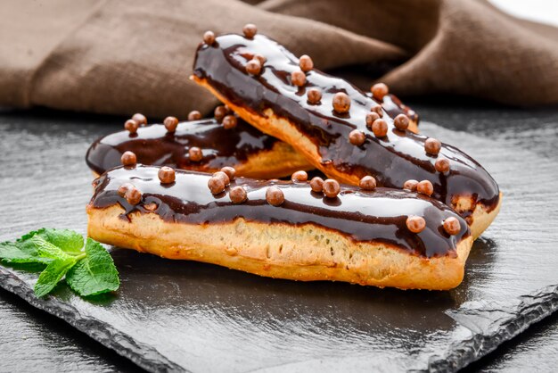 Eclair met chocoladesuikerglazuur en frambozen.