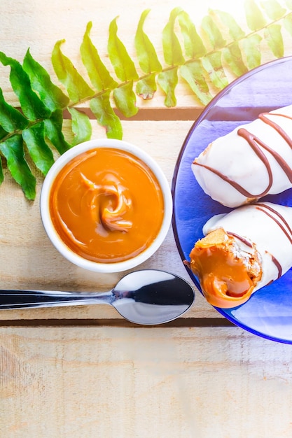 Eclair met Dulce de Leche vulling op houten tafel.