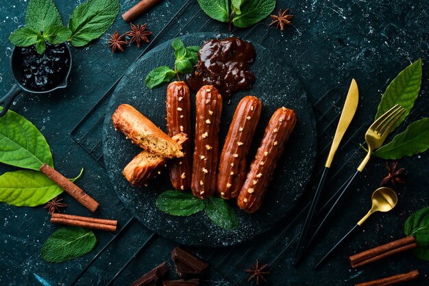 Eclair with caramel cream Caramel and nut dessert on a black stone plate Top view Rustic style