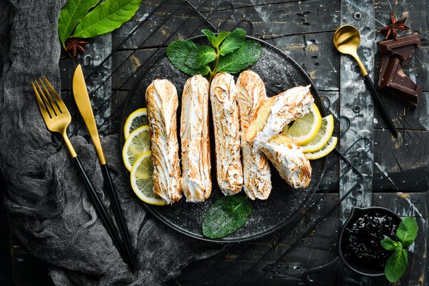 Eclair with lemon cream Lemon dessert on a black stone plate Top view Rustic style