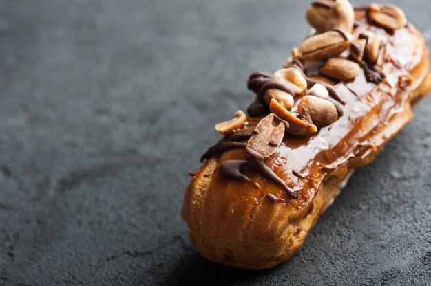 Eclair with peanuts, chocolate icing