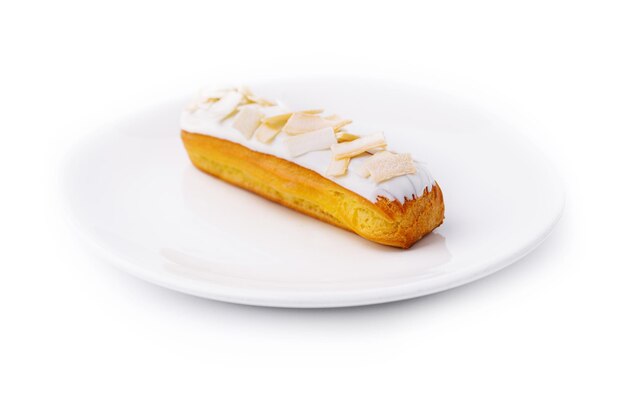 Eclair with white chocolate on white plate