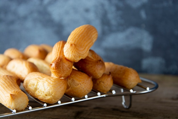 Eclairs of profiterole bereiden op bakplaat. Traditioneel Frans dessert.