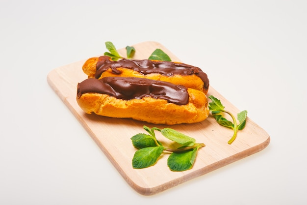 Eclairs on plate on a table on light