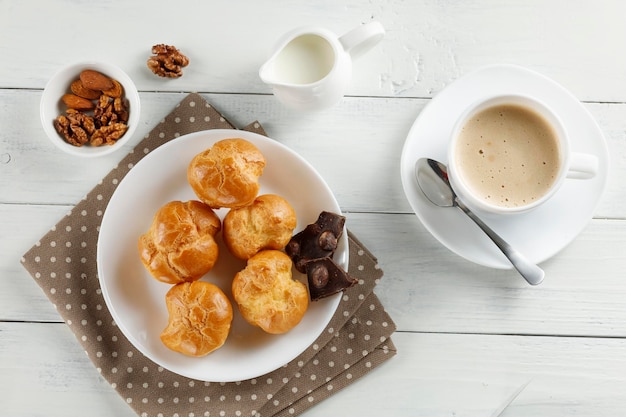 Eclairs with chocolate cappuccino and milk Sweet breakfast