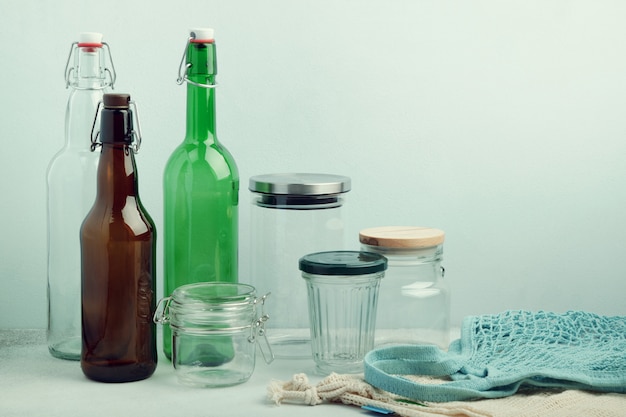 Eco bags, reusable glass bottles and jars on table. Sustainable lifestyle. Zero waste grocery shopping and storage concept