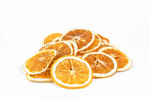 Eco biologische zelfgemaakte gedroogde sinaasappelschijfjes, chips. Gedehydrateerde knapperige fruitplakken. Hoop, stapel van in de zon gedroogde knapperige sinaasappelen. Gezonde snack. Detailopname. Ruimte kopiëren