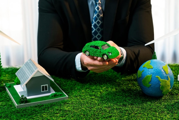 Eco-business en Save Earth-concept getoond door zakenman of CEO die papieren wereldbol op kantoor houdt met milieuvriendelijke mockup om de reductie van CO2 en de CO2-voetafdruk te bevorderen voor een groenere toekomst