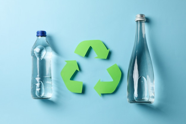 Eco concept with recycling symbol and bottles on blue