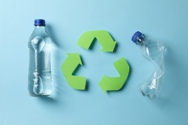 Photo eco concept with recycling symbol and bottles on blue