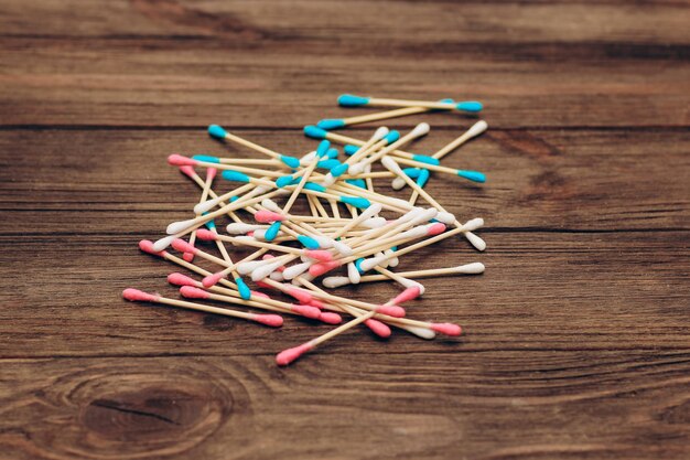 Foto eco cosmetische wattenstaafjes op een houten basis natuurlijk katoen in roze en blauwe kleur