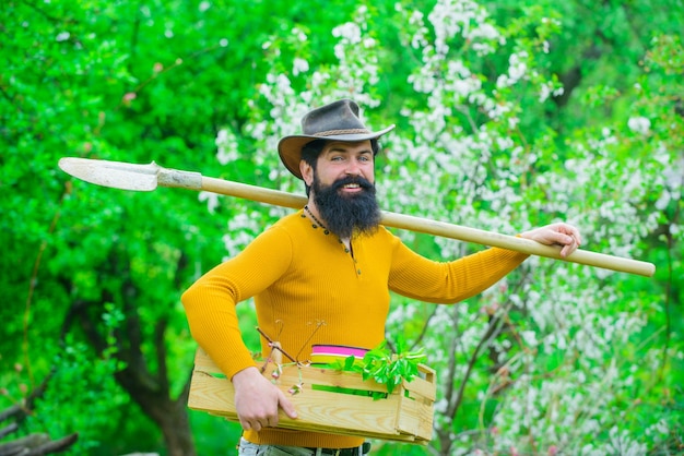 Eco farm man farmer gardening farmer works in garden farmer\
hold box spring farming bearded man