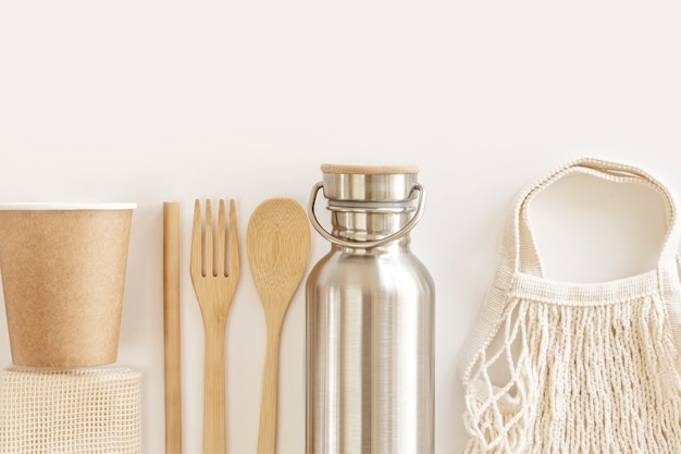 Eco friendly accessories - bamboo cutlery, eco bag, reusable water bottle. Zero waste, plastic free concept, sustainable lifestyle. Top view, flat lay.