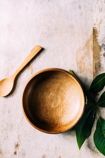 Eco-friendly background. green leaves and a wooden bowl on the table. 