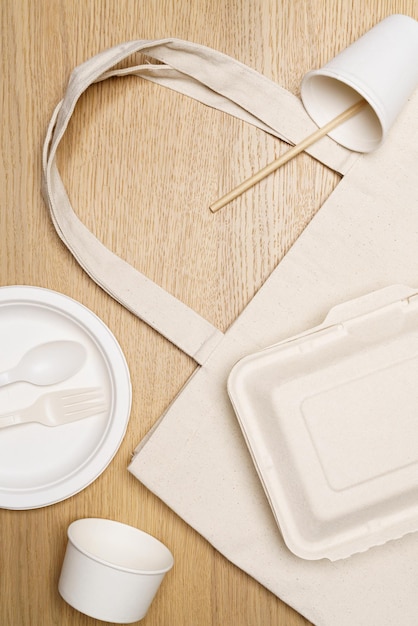 Экологически чистая концепция Эко-сумка с пищевым контейнером на деревянном фоне