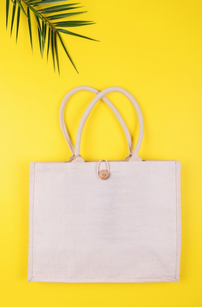 Eco friendly cotton bag with palm leaf on a yellow , copyspace, minimal nature style. Environmental Conservation Recycling 