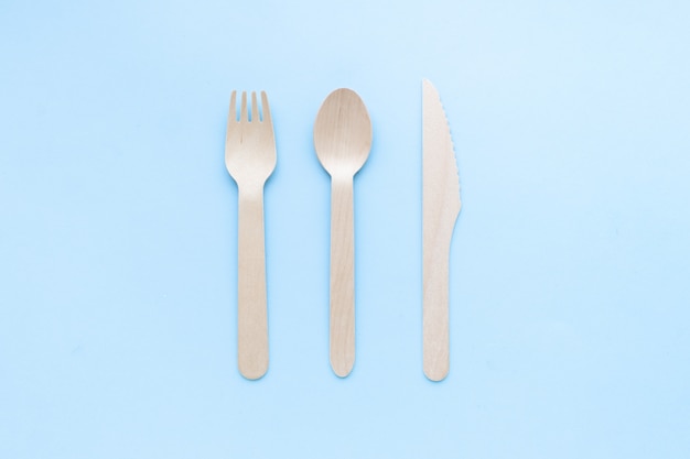 eco friendly disposable kitchenware utensils on blue background. wooden forks and spoons. ecology, zero waste concept. top view. flat lay