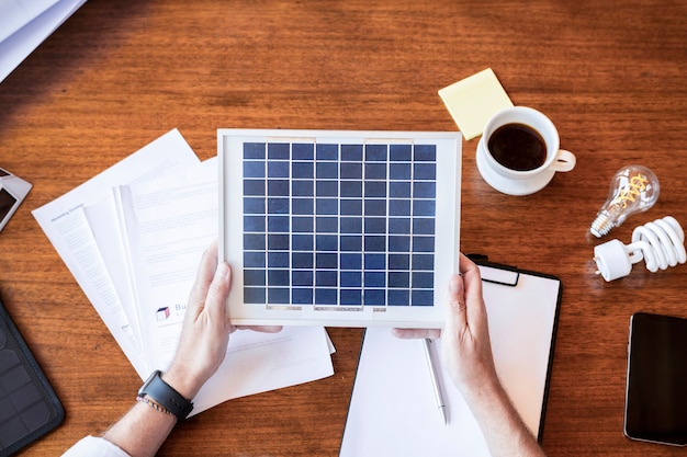 Photo eco-friendly engineer holding a solar panel