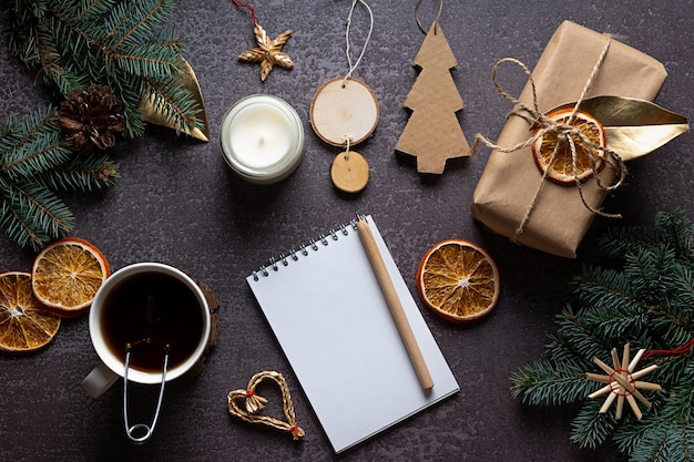 Eco-friendly and hand-crafted Christmas decorations, a blank notebook on dark background