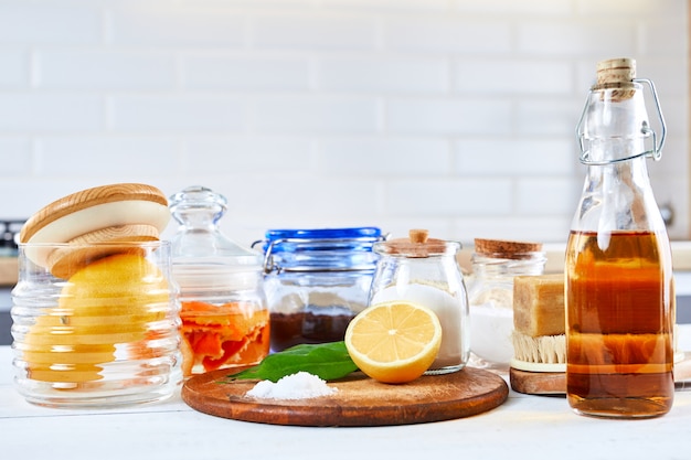 Eco-friendly natural cleaners: baking soda, soap, vinegar, salt, coffee, lemon and brush on a wooden table