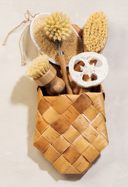 Eco friendly natural cleaning tools and products, bamboo and coconut kitchen brushes, luffa sponge on a beige background. Zero waste concept. Flat lay, top view