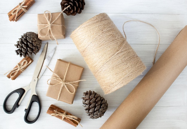 Eco friendly packaging gifts in kraft paper on a light wooden background christmas zero waste concept