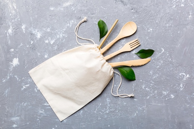 Eco friendly reusable recyclable white eco bag with kitchenware on Colored background Concept zero waste