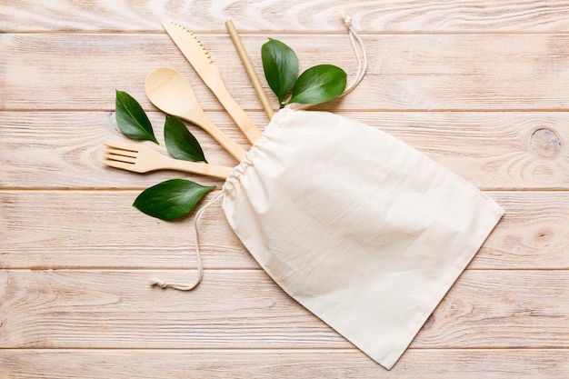 Eco friendly reusable recyclable white eco bag with kitchenware on Colored background Concept zero waste