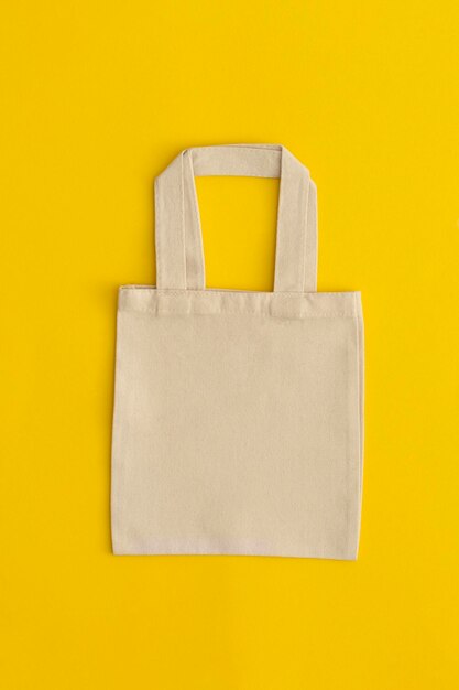 Photo eco friendly reusable recyclable white eco bag on yellow background