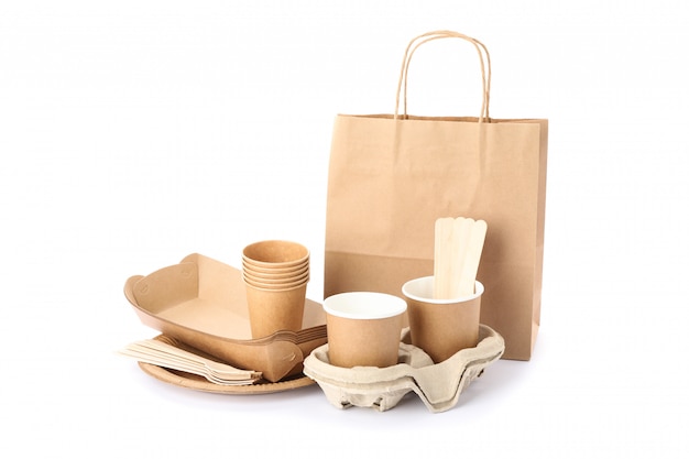 Eco - содружественная посуда и бумажная сумка изолированные на белизне. Одноразовая посуда