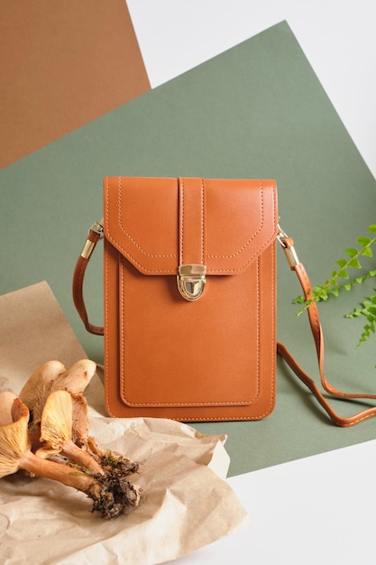 Eco-friendly vegan leather concept, bag made of eco-leather made from mushroom mycelium, mushrooms and fern on a green background, no use of animal skin