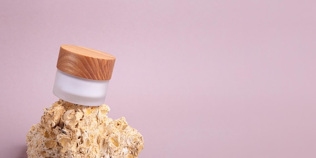 Eco friendly white cream container with wooden cover on the natural stones Good as cosmetics mockup