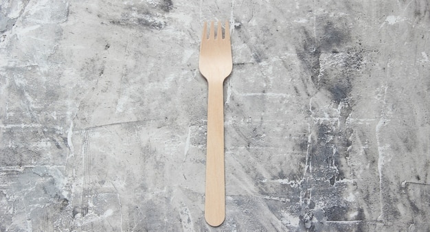 Eco-friendly wooden forks on gray concrete background. Top view