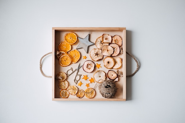친환경적인 제로 웨이스트 말린 오렌지 조각과 DIY 도구 및 테이블 위의 물건을 손으로 건조