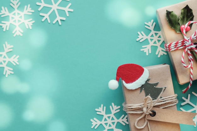 緑のパステル調の背景にクリスマススノーフレーク装飾とエコギフトボックス
