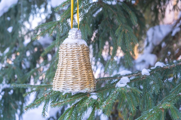 Eco handgemaakt speelgoed op een dennentak. Dennenboom, sneeuwvlokken en klokvormig speelgoed. Kerststemming, winter.