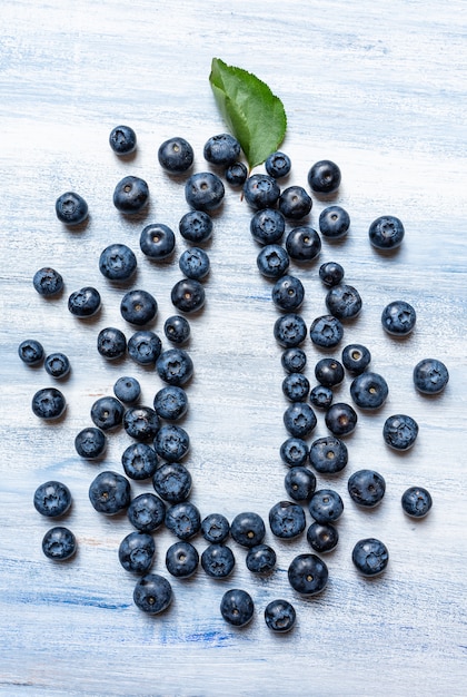 Eco juice bottle concept. Blueberry make silhouette bottle on blue wall. Top view mock up. Copy space for design or logo. picture for natural juice