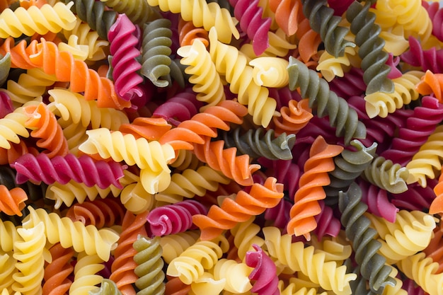 Eco macaroni pasta in een houten kom op een grijze achtergrond.