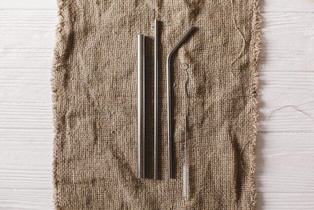 Eco natural metallic straws flat lay on rustic background sustainable lifestyle concept zero waste plastic free items stop plastic polution reuse reduce recycle refuse