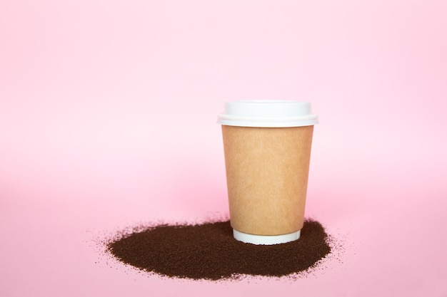 Eco paper cup of coffee on pink background copy space hot drink