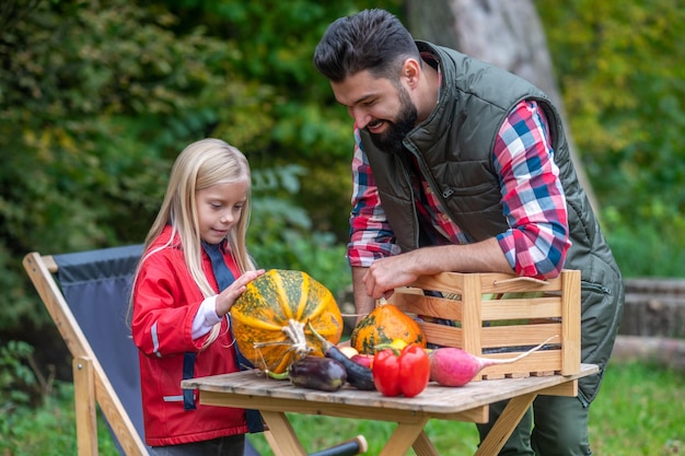 Eco products. Dad and daughter spending time on a farm sorting the vegetables