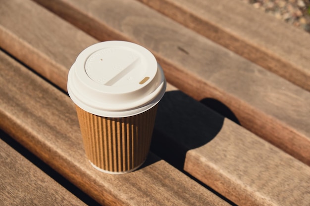 Eco-recycling papieren beker met koffie of thee op kraftpapier op houten tafel ontbijt op straat