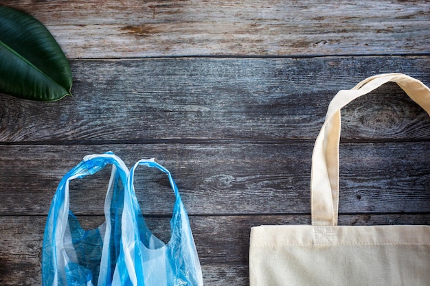 Eco Shopping Bag tegen een plastic zak op houten achtergrond Flat Lay Save planet earth