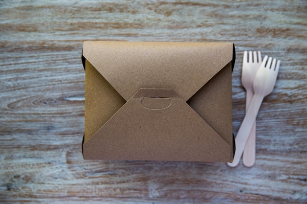 Eco-vriendelijke kartonnen serviesdoos en houten vorken Recyclebaar servies voor het bezorgen van eten